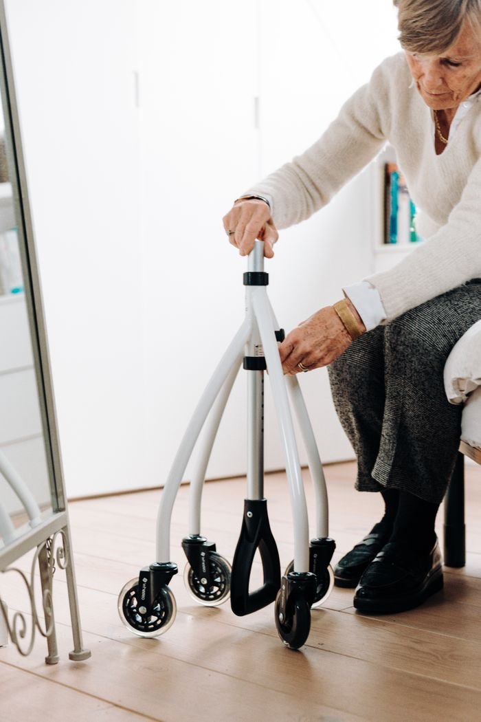 services-02 Elderly woman making adjustments to her rollator walker at home.