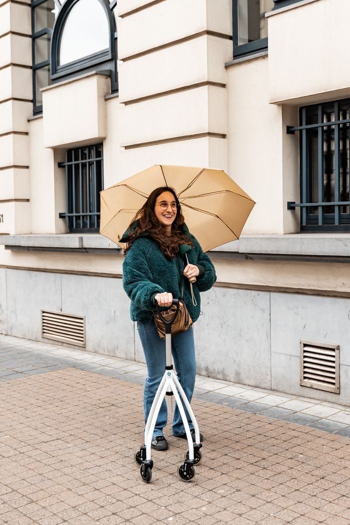 Crafting Captivating Headlines: Your awesome post title goes here Woman with a rollator and umbrella, standing confidently on a city street.